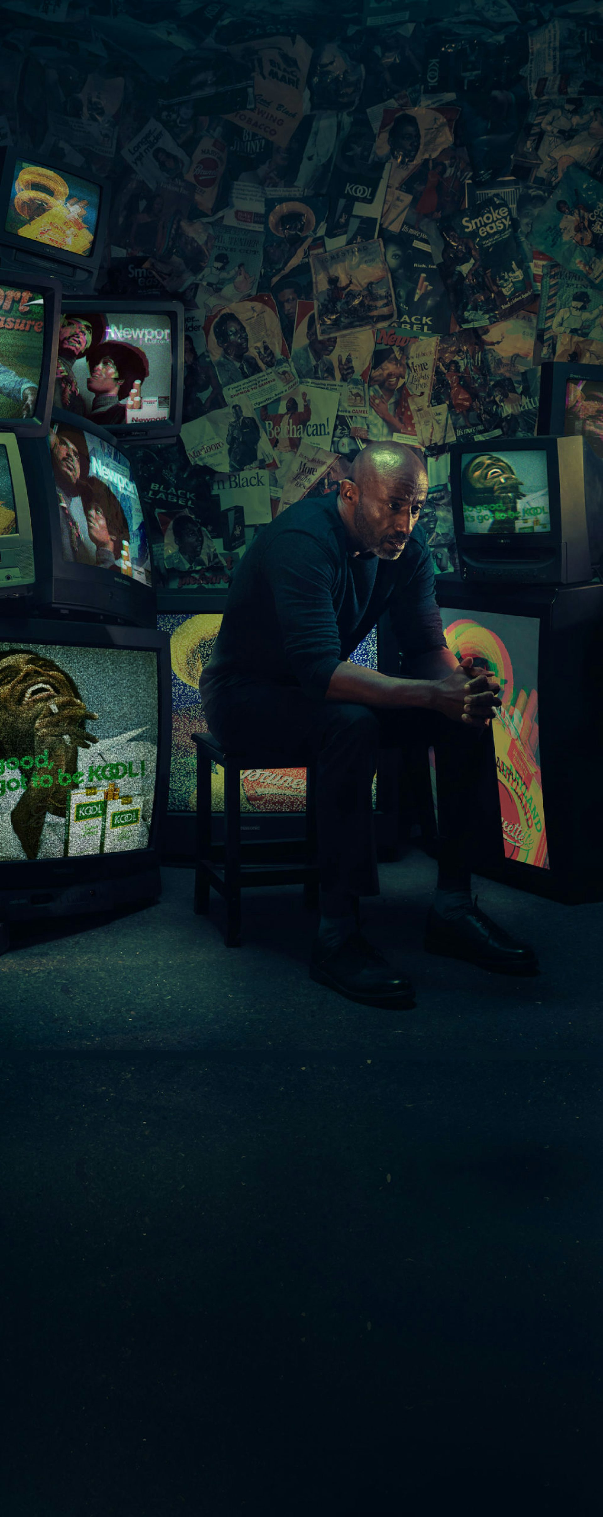 An African American/Black man sitting on a chair watching cigarette ads